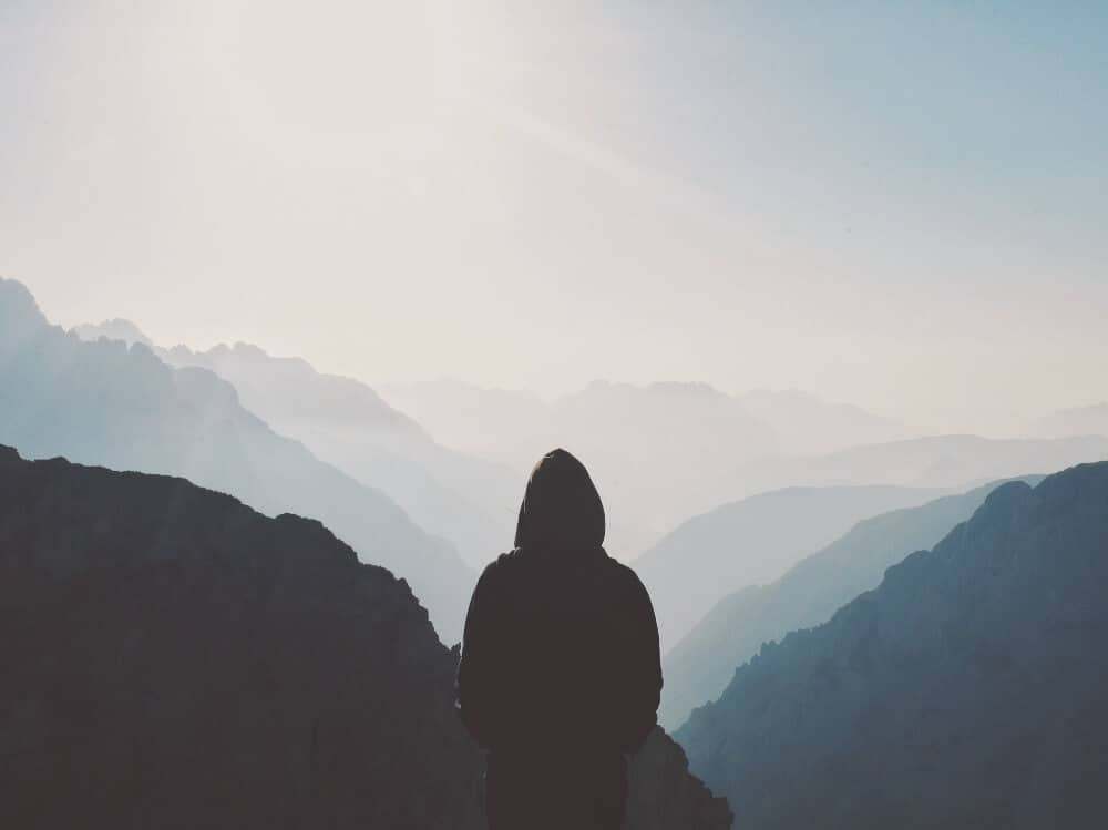 Silhouette of a man with the shadows of hills. Knowing the triggers is the first step in tackling loneliness. 