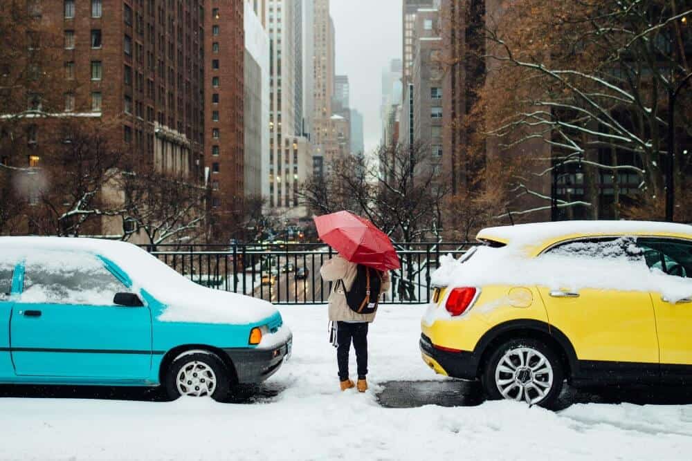 How to Plan the Perfect Festive Winter Mini-Break 7 Someone walking with an umbrella and backpack on in New York