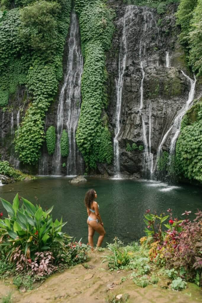 Travelling Alone While in a Relationship: Can You Do It? 3 Woman in a bikini posing in front of a waterfall