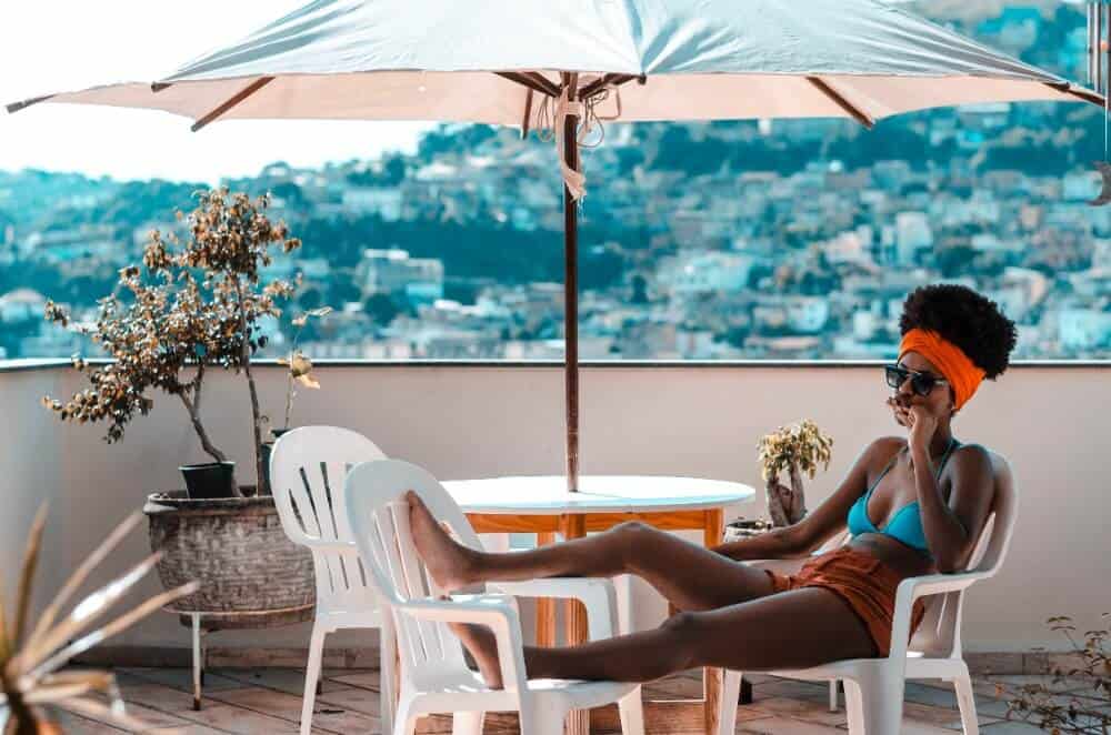 Travelling Alone While in a Relationship: Can You Do It? 8 Woman sitting under an umbrella