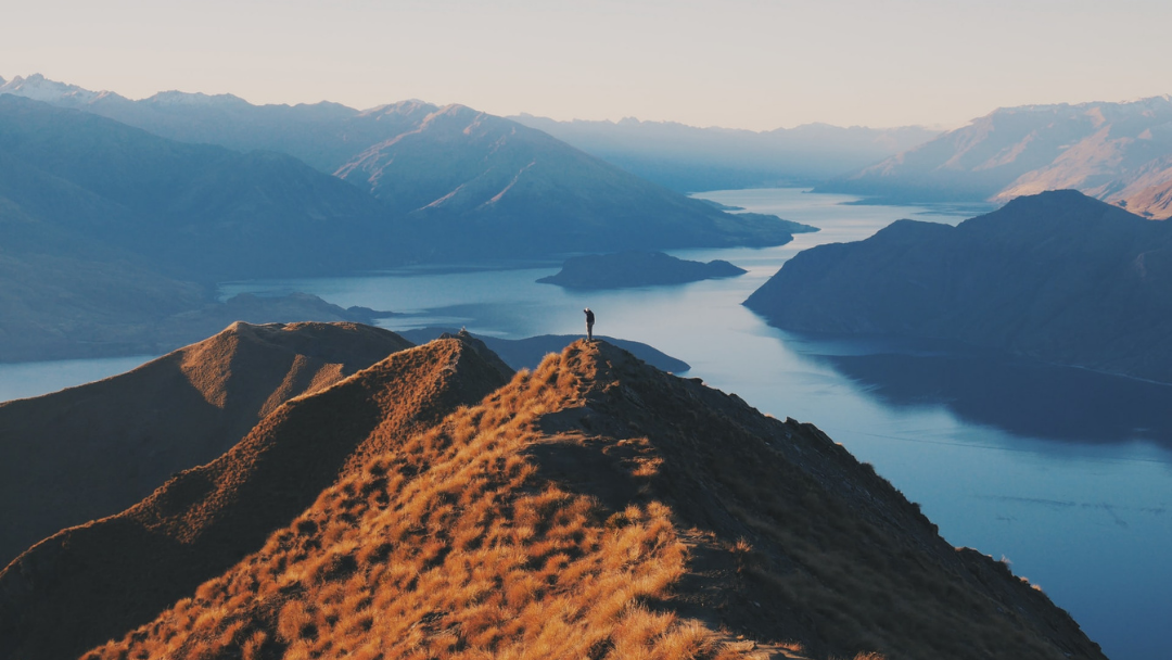 Person on top of Roy's Peak for New Zealand travel tips.