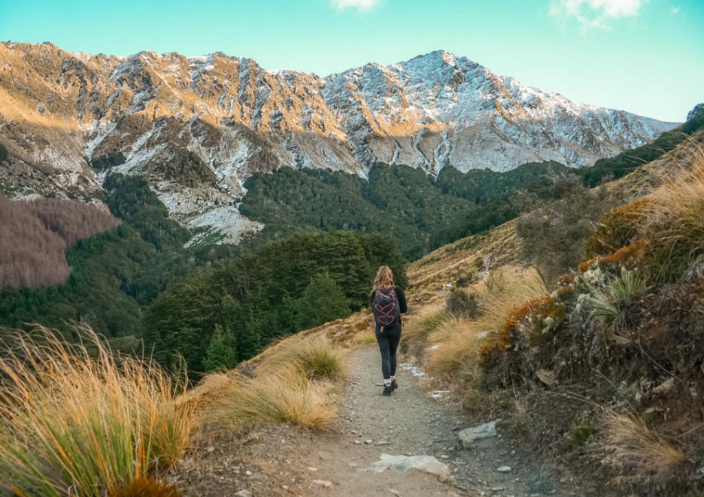 14 Incredible Hikes On the South Island of New Zealand 4 A girl walking along a path up Ben Lomond, one of the best hikes on the South Island of New Zealand.