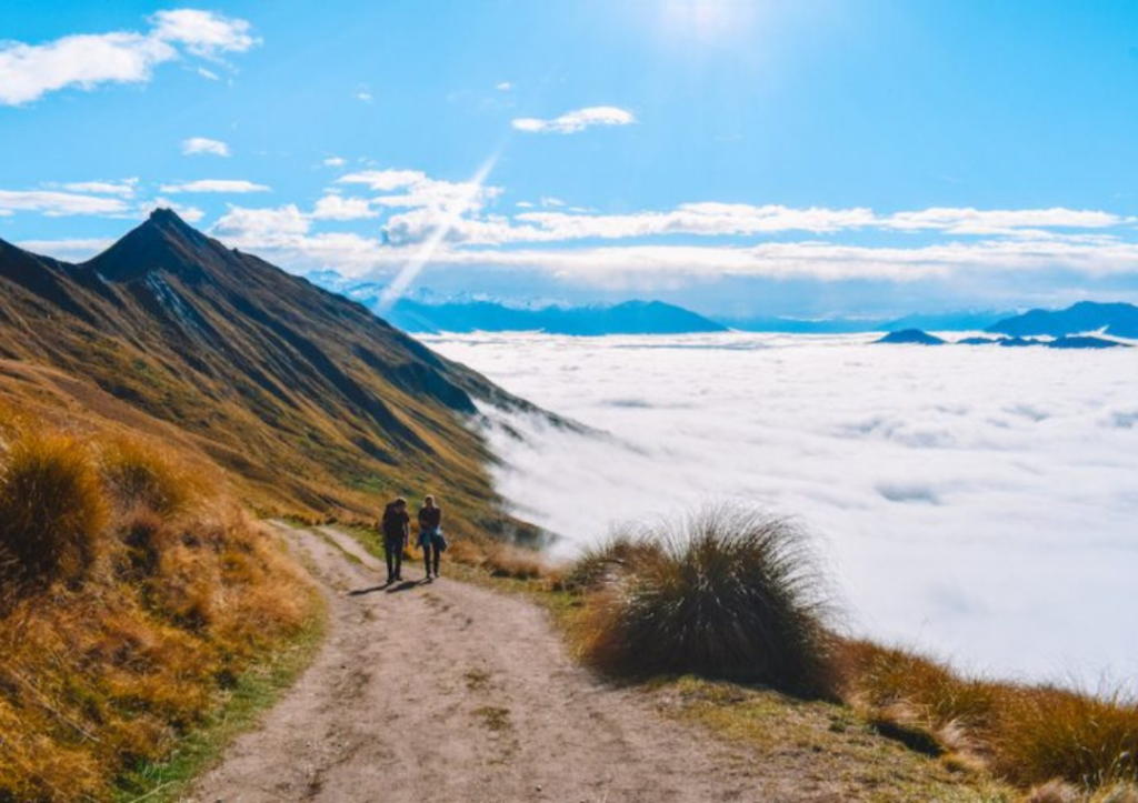 14 Incredible Hikes On the South Island of New Zealand 3 Two people walking on a trail in the mountains at Roy's Peak.
