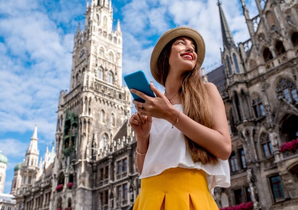 Woman in a city on her own with a blue phone. 