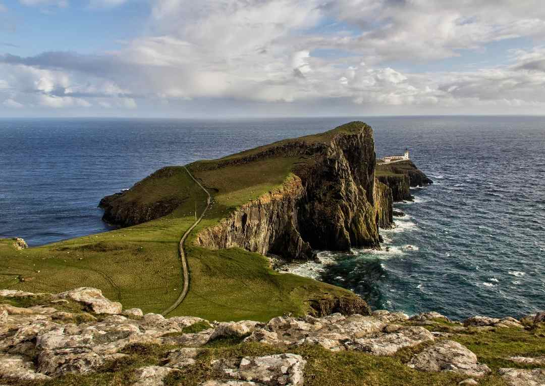 Neist Point, Skye. a lighthouse sitting on a peninsula jutting into the sea.