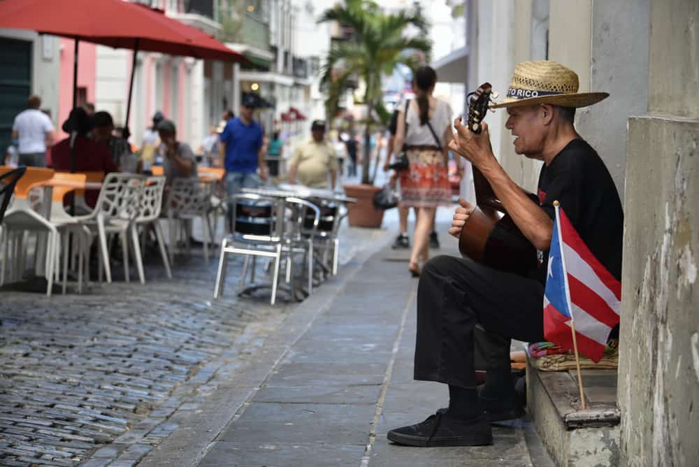 SAN JUAN, PUERTO RICO - MARCH 20: A street performer serenades visitors for tips in Old San Juan on March 20, 2016. Tourism revenue has remained relatively unaffected by the island's budget crisis.
