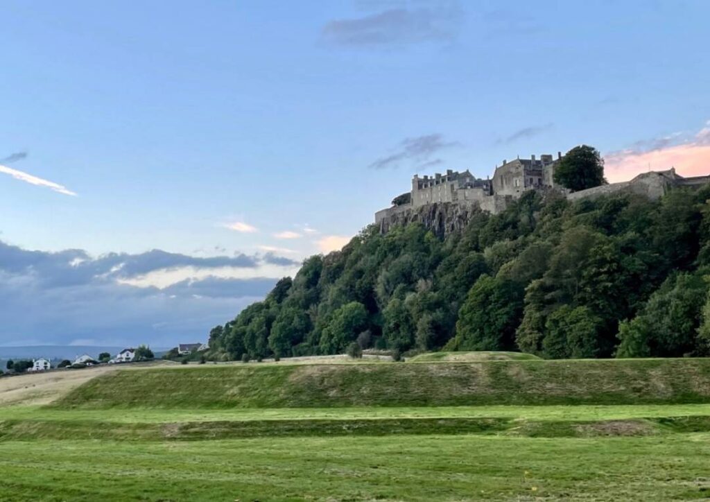 Stirling Castle on a hill in Scotland surrounded by trees. 