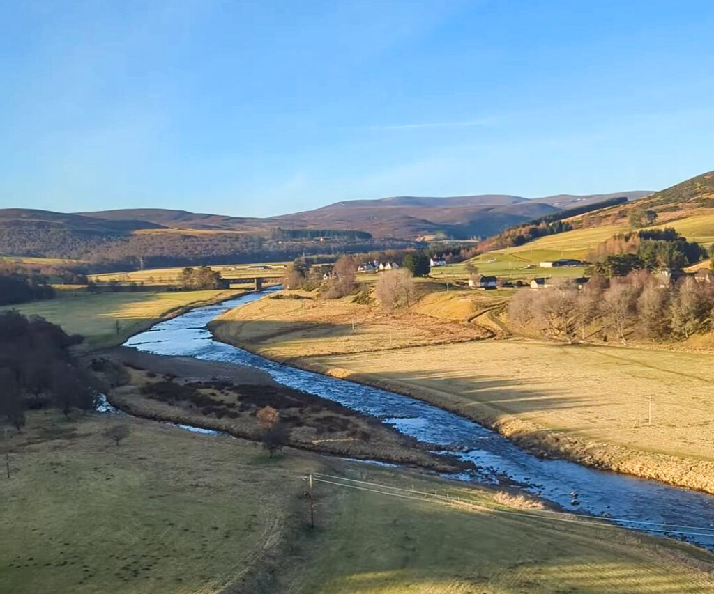A river winding though the countryside in Scotland on a train from London to Edinburgh. 