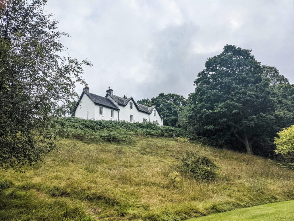 A white house with a slate roof on a hill in Spean Bridge near Fort William.  
