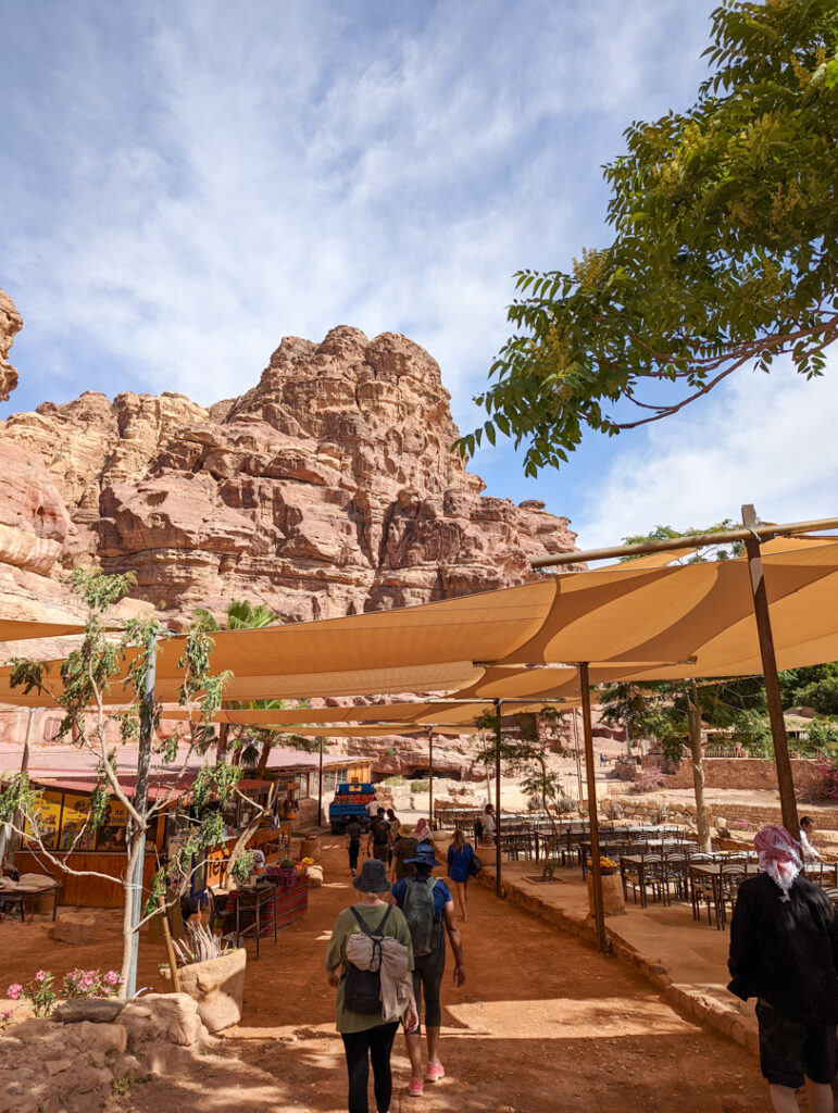 Tented coverings with a cliff face behind. The restaurant spot in Petra. 