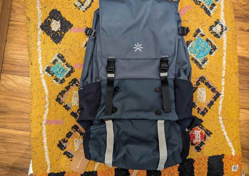 Blue tropicfeel shell bag on a colourful orange patterned rug. 
