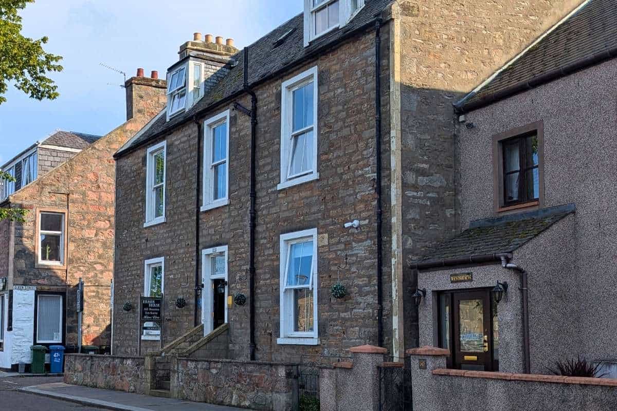 A large house with brown brick mostly in shadow with white wainscotting. Fraser House exterior in Inverness for where to stay in Inverness. 