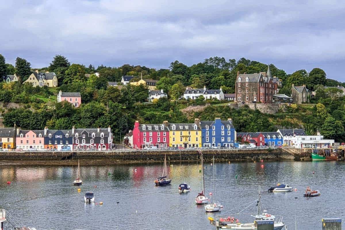 Colourful houses line a harbourfront with boats bobbing in the water. Tobermory on the Isle of Mull. 