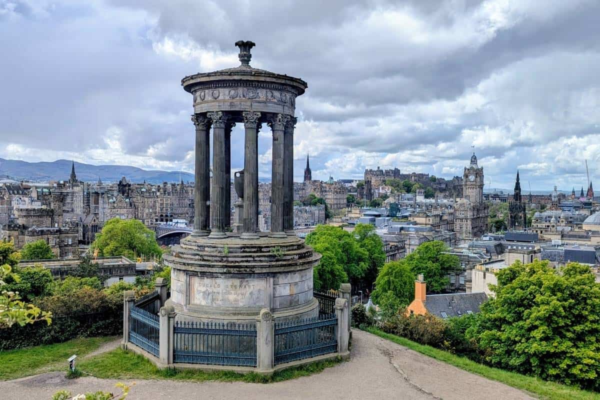View of Edinburgh city skyline with the Dugald Stewwart Monument in front of it. 
