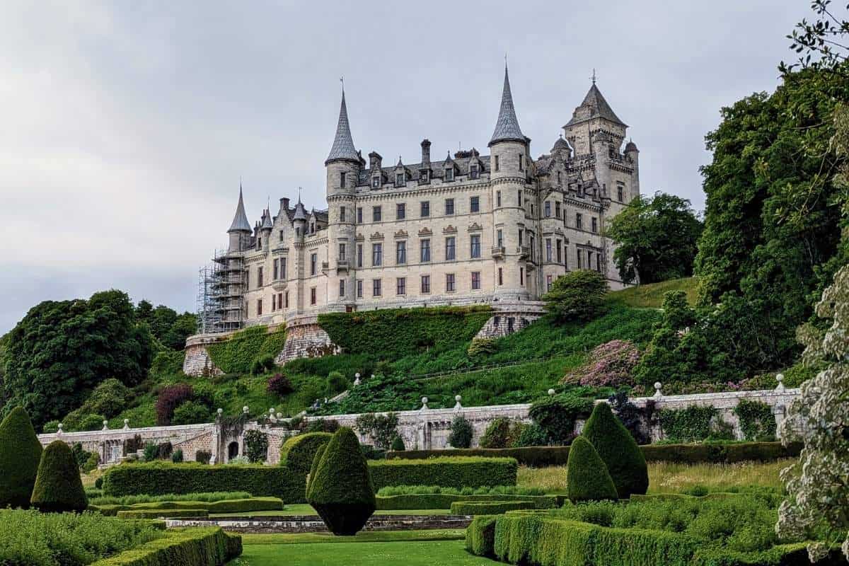10 Easy Day Trips from Inverness Without a Car 8 A palatial looking castle sits on a hill surrounded by formal gardens. Dunrobin Castle is one of the best easy day trips from Inverness without a car.