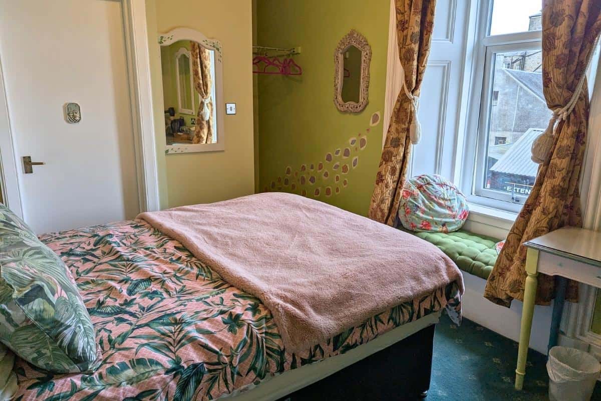 Where to Stay in Scotland Without a Car: Best Areas + Hotels 10 A colourful green and pink room. Lagganbeg guesthouse in Oban.