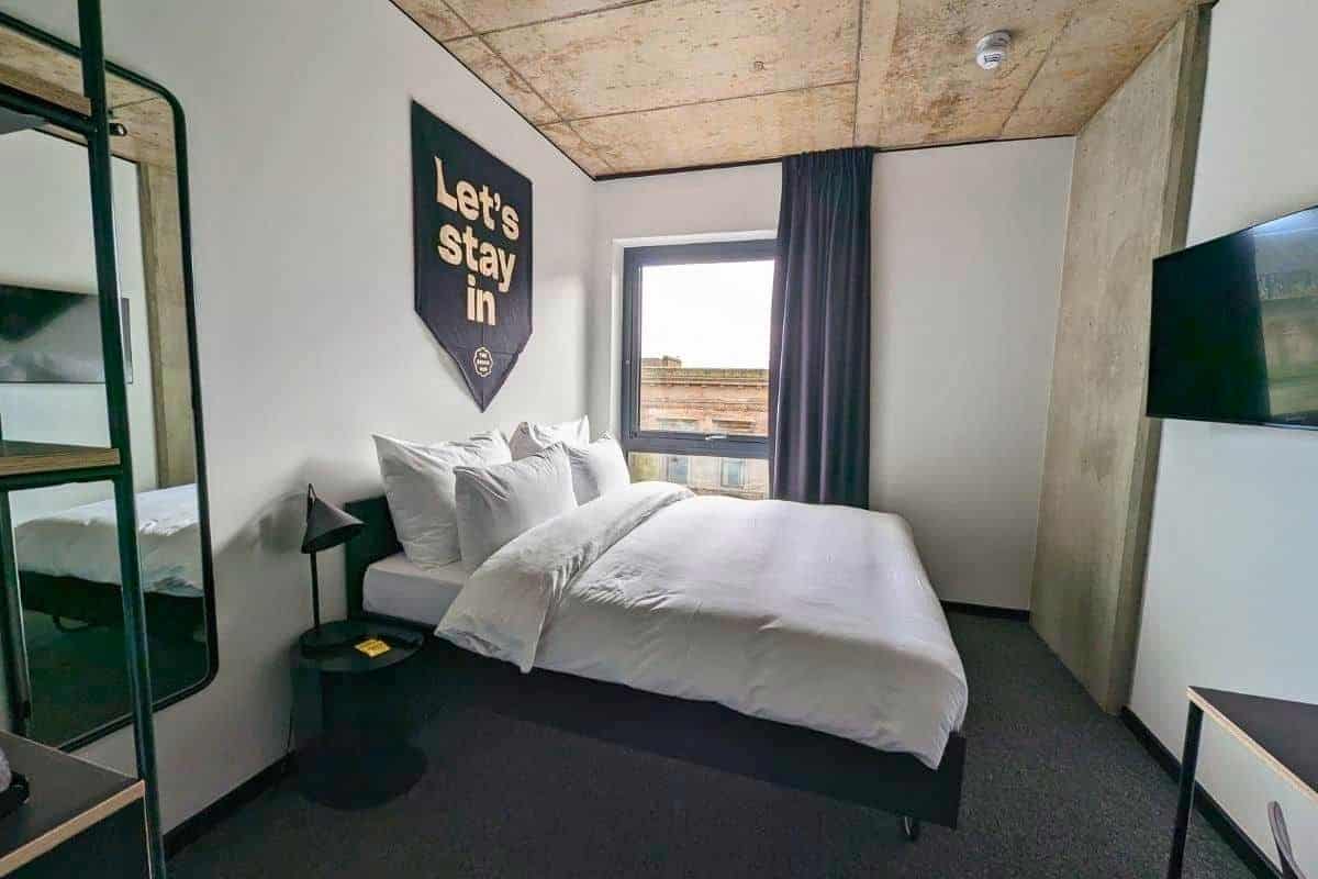 Where to Stay in Scotland Without a Car: Best Areas + Hotels 8 View of a white bed and black furnishings. A room at The Social Hub Glasgow.